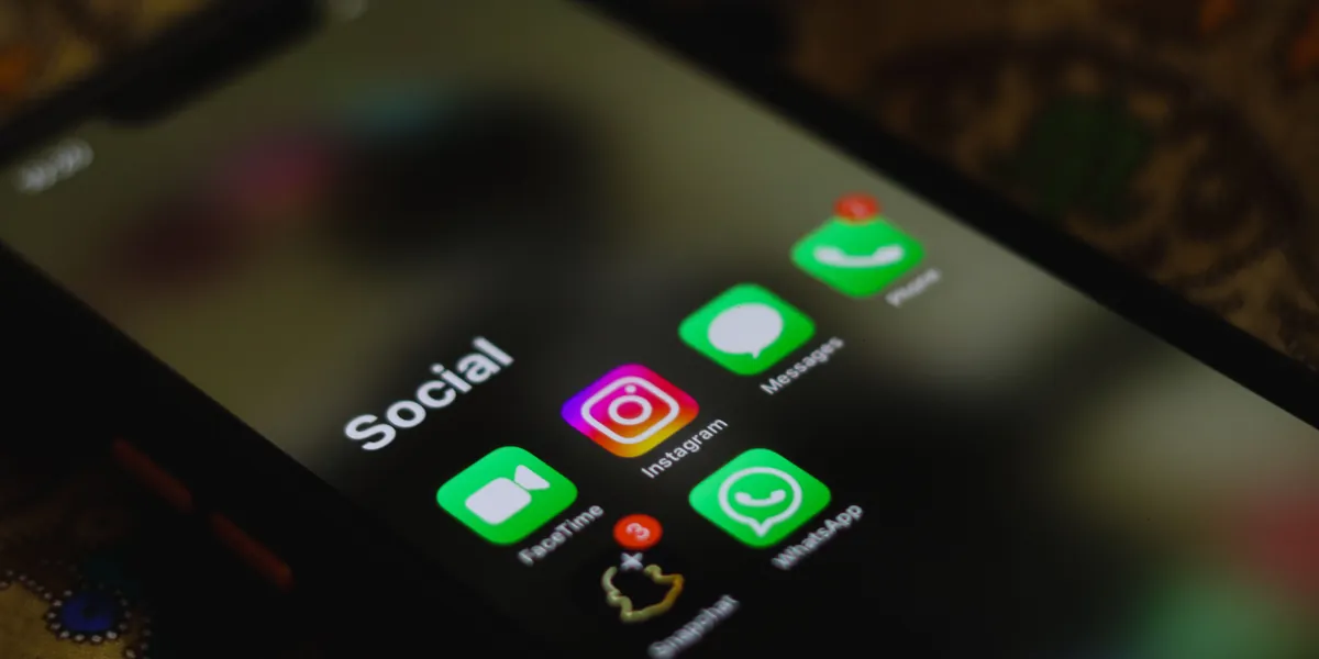 Ecran de telefon cu dosarul „Social” deschis: Instagram, WhatsApp, Messages și FaceTime, unul lângă altul.