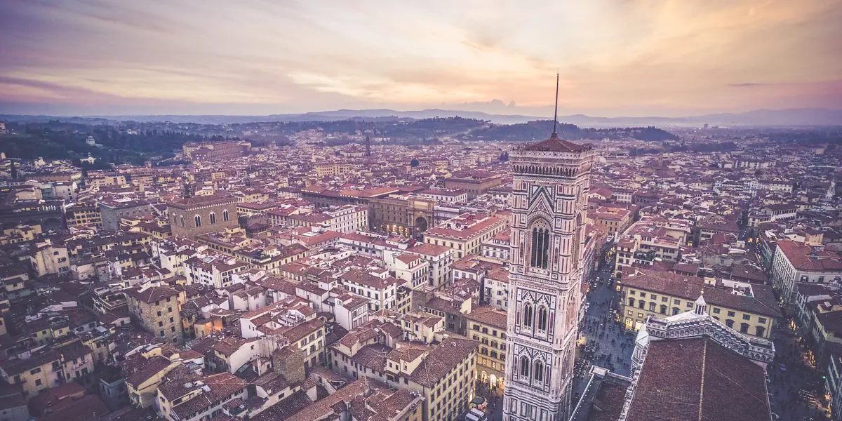 Vedere aeriană a Florenței la apus, cu cupola Domului și campanila lui Giotto în centru și acoperișurile de cărămidă întinse până la dealuri