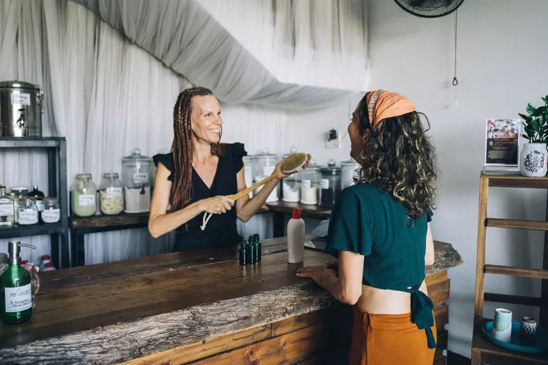 Two women talking at a café counter, in warm light
