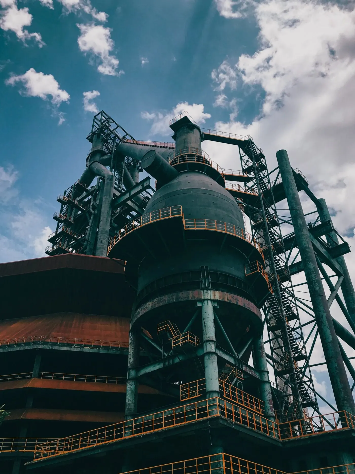 Un impianto industriale di trattamento acque in penombra, tubazioni e serbatoi illuminati a bassa intensità — l'ambiente per cui sono costruiti i filtri Ecoklin.